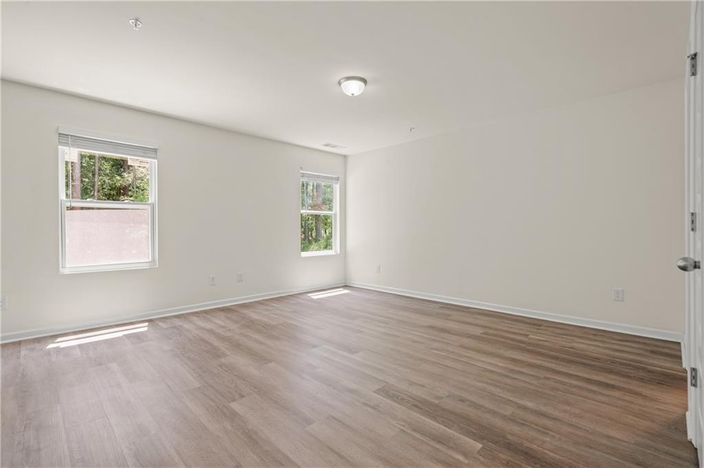 631 Carlton Pointe Drive, Unit 24 Palmetto, GA 30268 - Photo 19 of 20 an empty room with wooden floor and windows