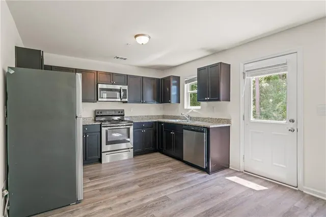 a kitchen with stainless steel appliances granite countertop a refrigerator and a stove top oven