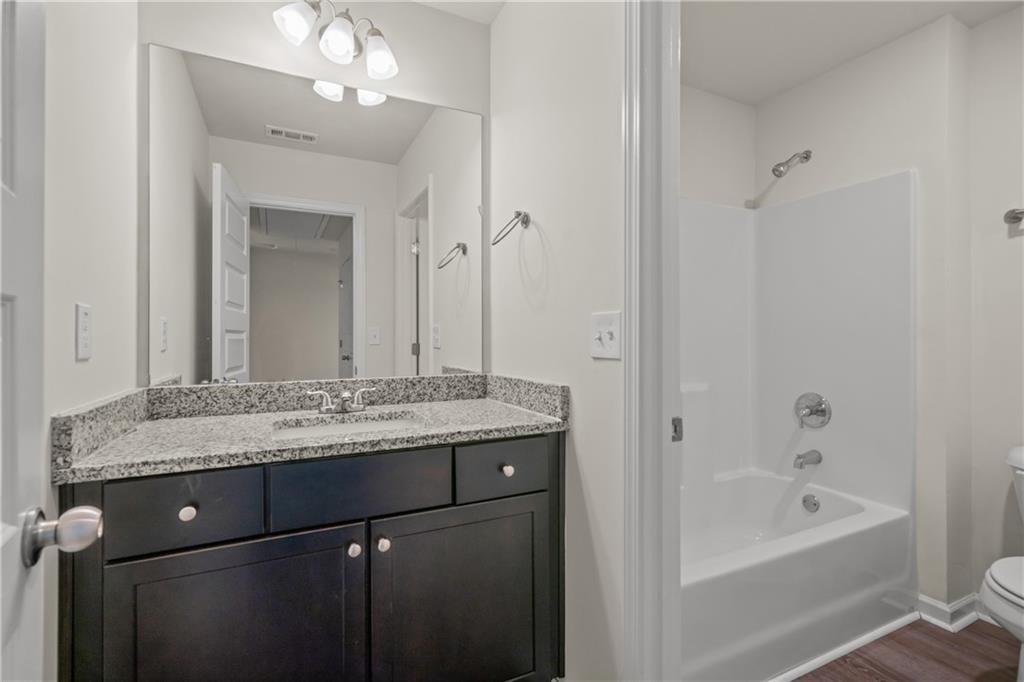 631 Carlton Pointe Drive, Unit 24 Palmetto, GA 30268 - Photo 10 of 20 a bathroom with a granite countertop sink a mirror a vanity and a bathtub