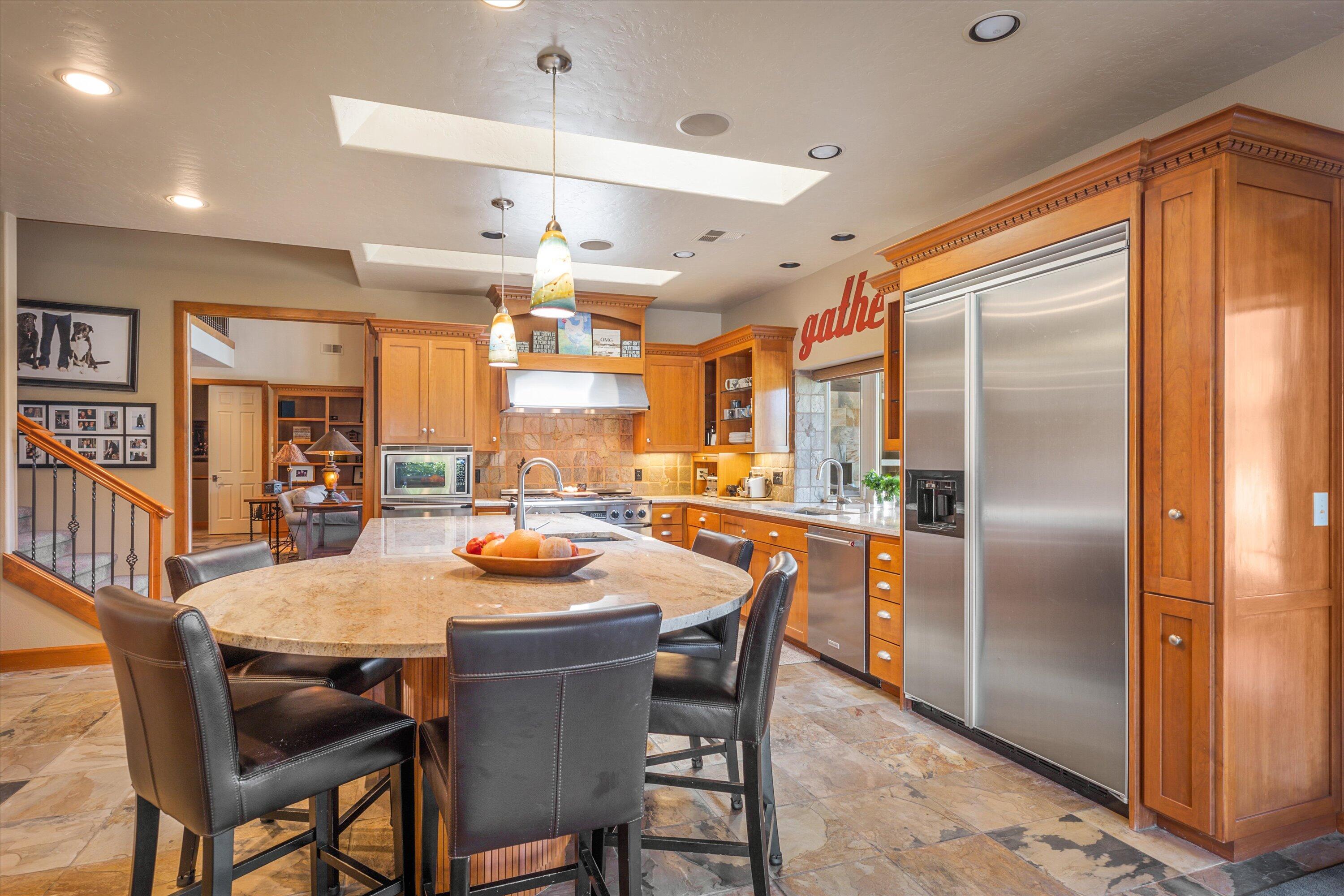 60540 Woodside Road Bend, OR 97702 - Photo 16 of 38 a kitchen with a table chairs and refrigerator