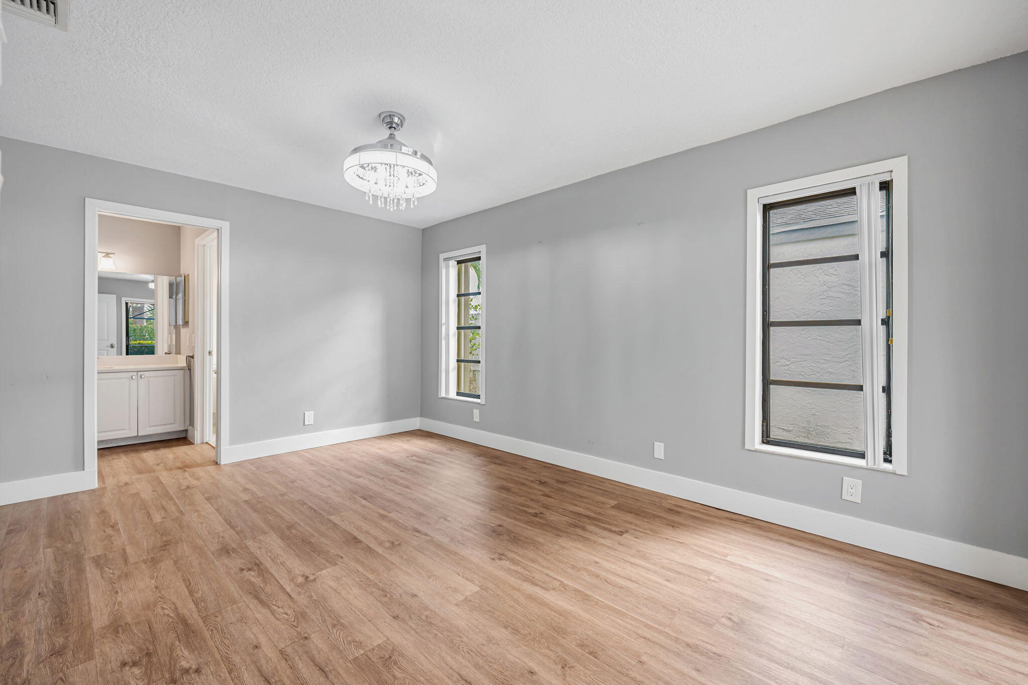 21356 Summertrace Circle Boca Raton, FL 33428 - Photo 12 of 33 an empty room with wooden floor chandelier and windows