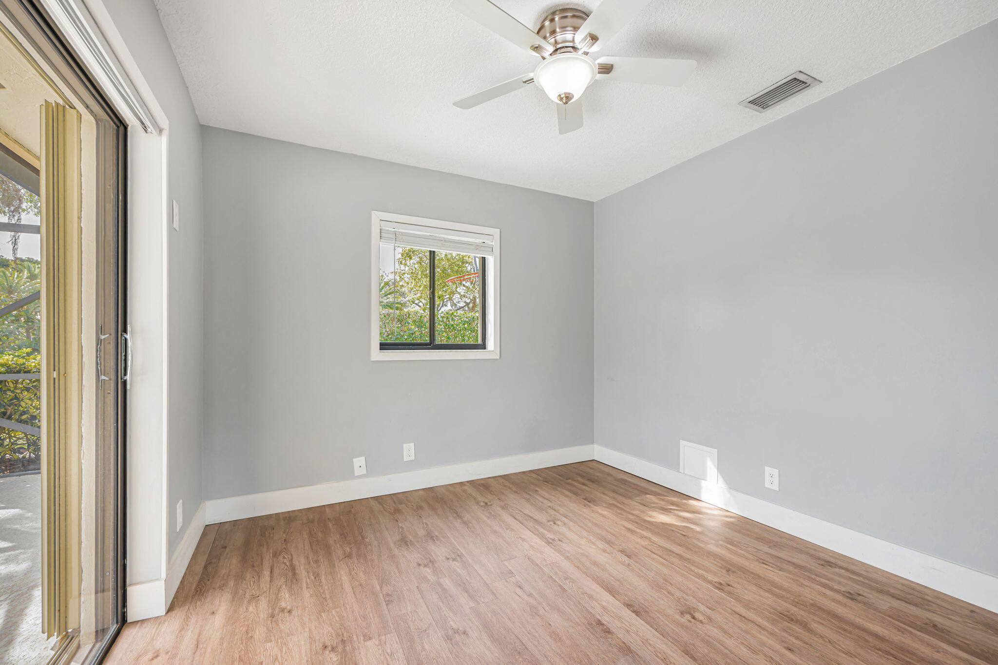 21356 Summertrace Circle Boca Raton, FL 33428 - Photo 17 of 33 an empty room with wooden floor and windows