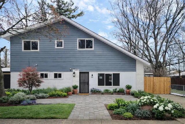 a front view of a house with a yard and potted plants