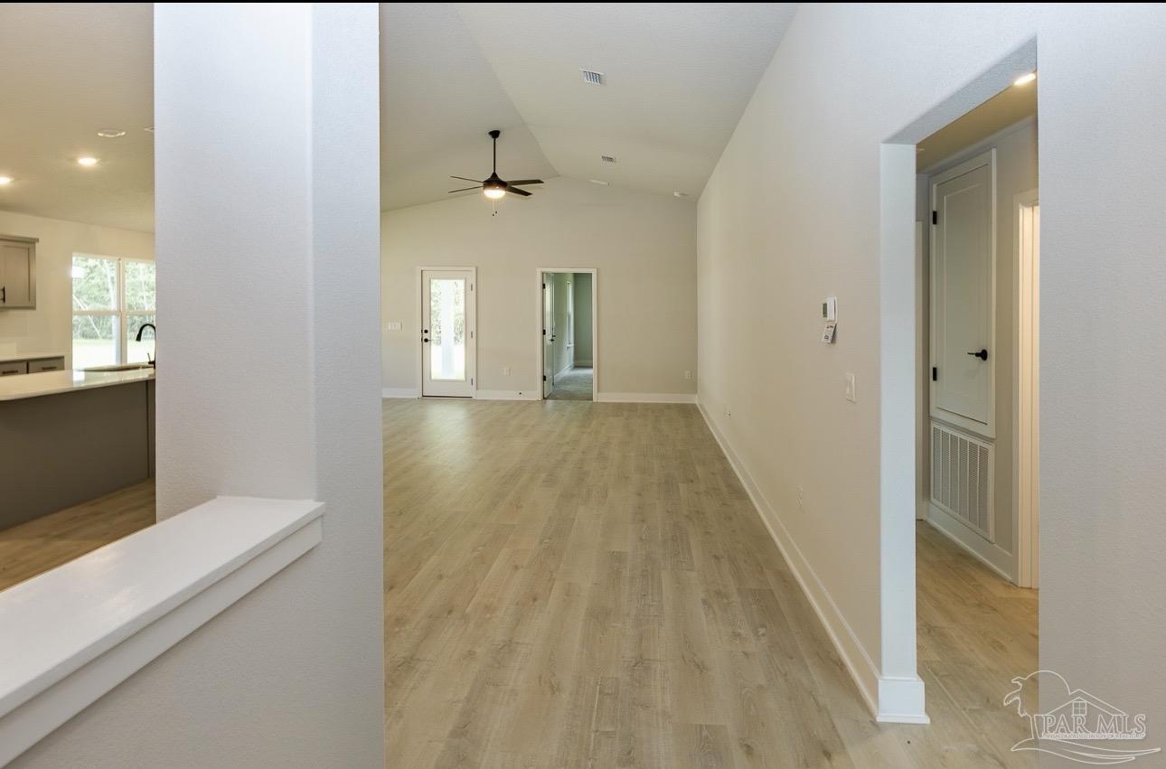 7657 Small Pnes Street Milton, FL 32583 - Photo 6 of 26 a view of a hallway with wooden floor and a living room