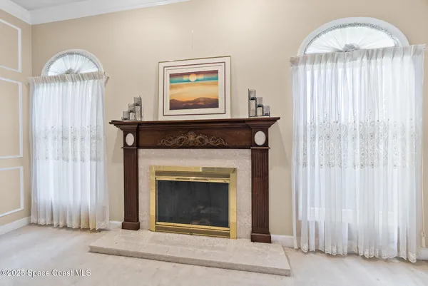 a bedroom with a large bed a flat tv screen and a chandelier