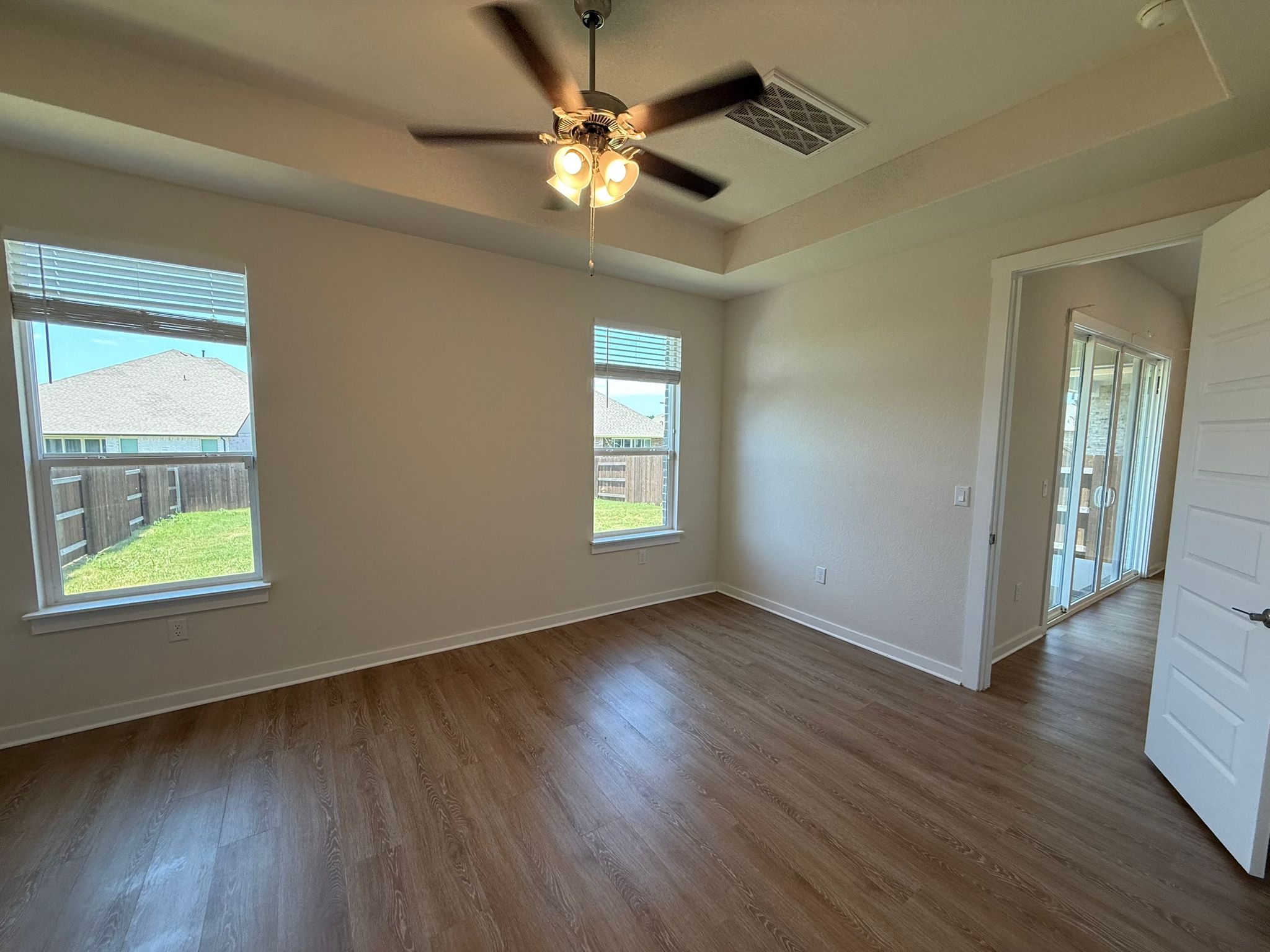 2037 Saddlery Street Leander, TX 78641 - Photo 16 of 38 an empty room with wooden floor chandelier fan and windows
