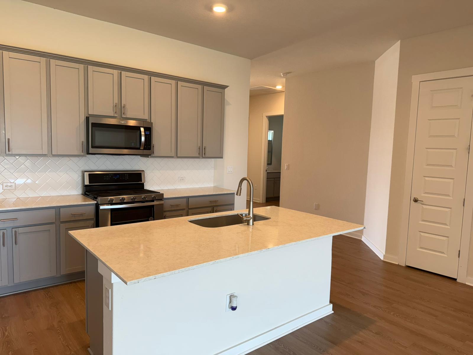 2037 Saddlery Street Leander, TX 78641 - Photo 18 of 38 a kitchen with a sink a microwave and cabinets