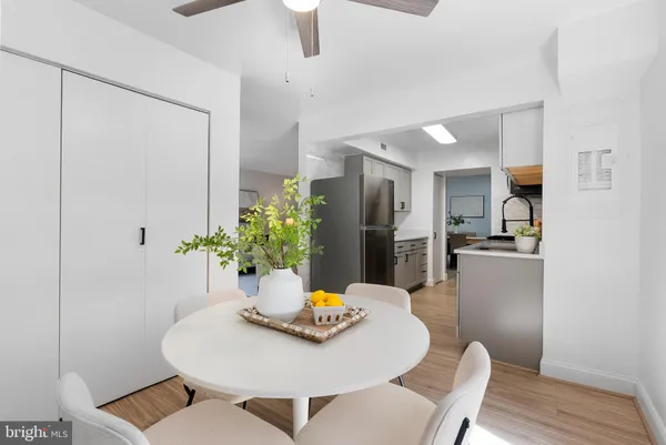 a kitchen with a dining table chairs and refrigerator