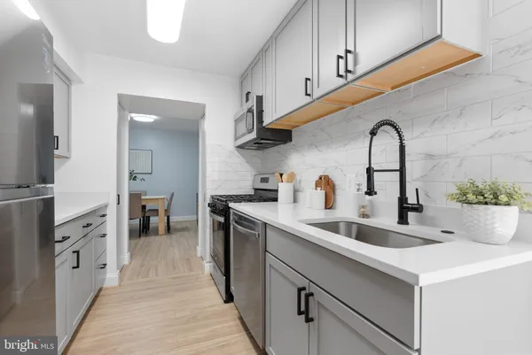 a kitchen with stainless steel appliances a sink and cabinets