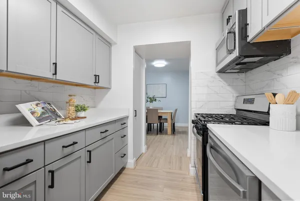 a kitchen with stainless steel appliances granite countertop a lot of cabinets a stove and a sink