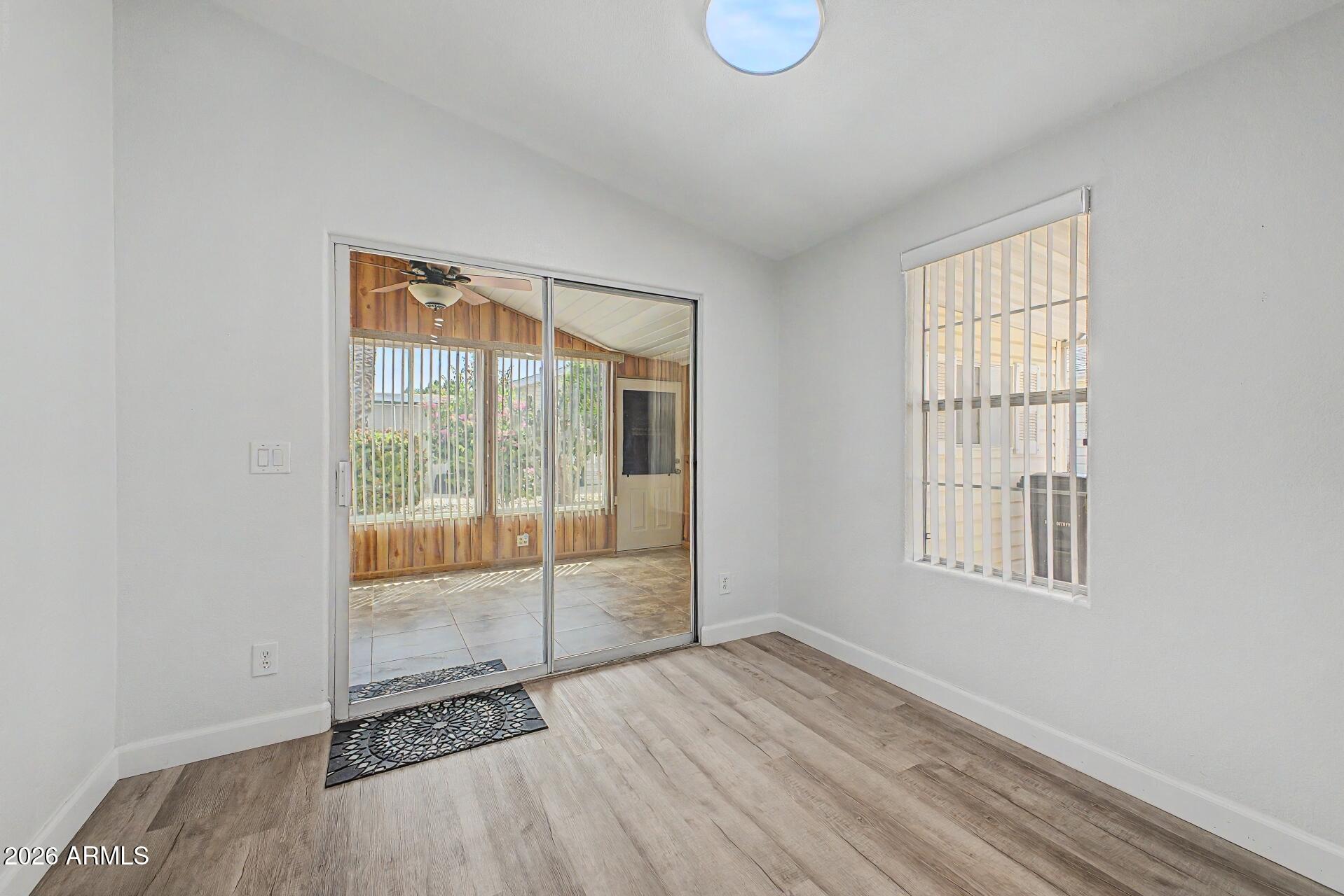 2550 South Ellsworth Road, Unit 50 Mesa, AZ 85209 - Photo 11 of 45 an empty room with wooden floor and windows