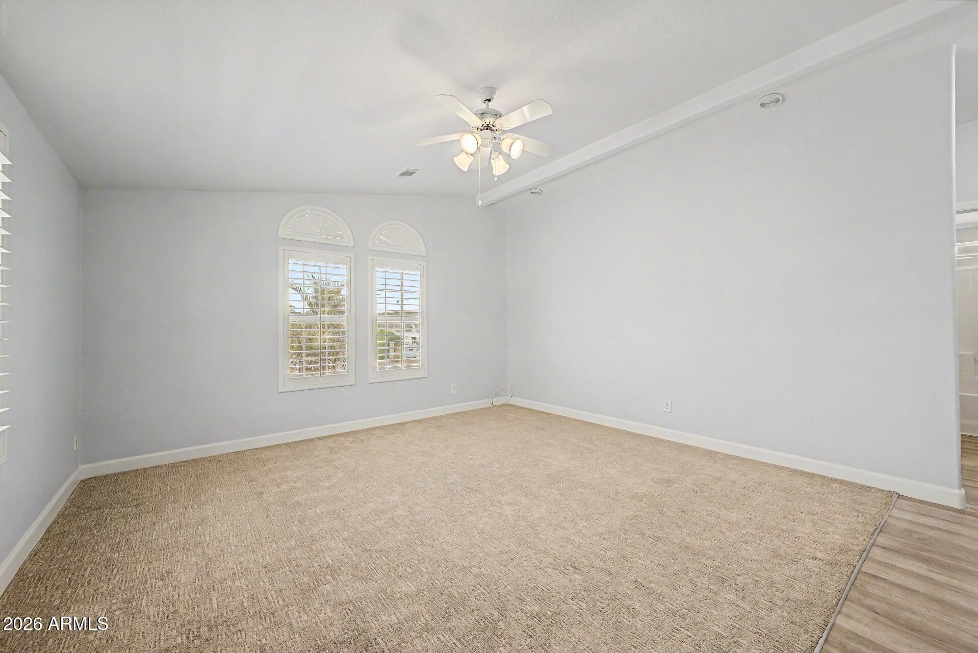 2550 South Ellsworth Road, Unit 50 Mesa, AZ 85209 - Photo 14 of 45 an empty room with windows and chandelier fan