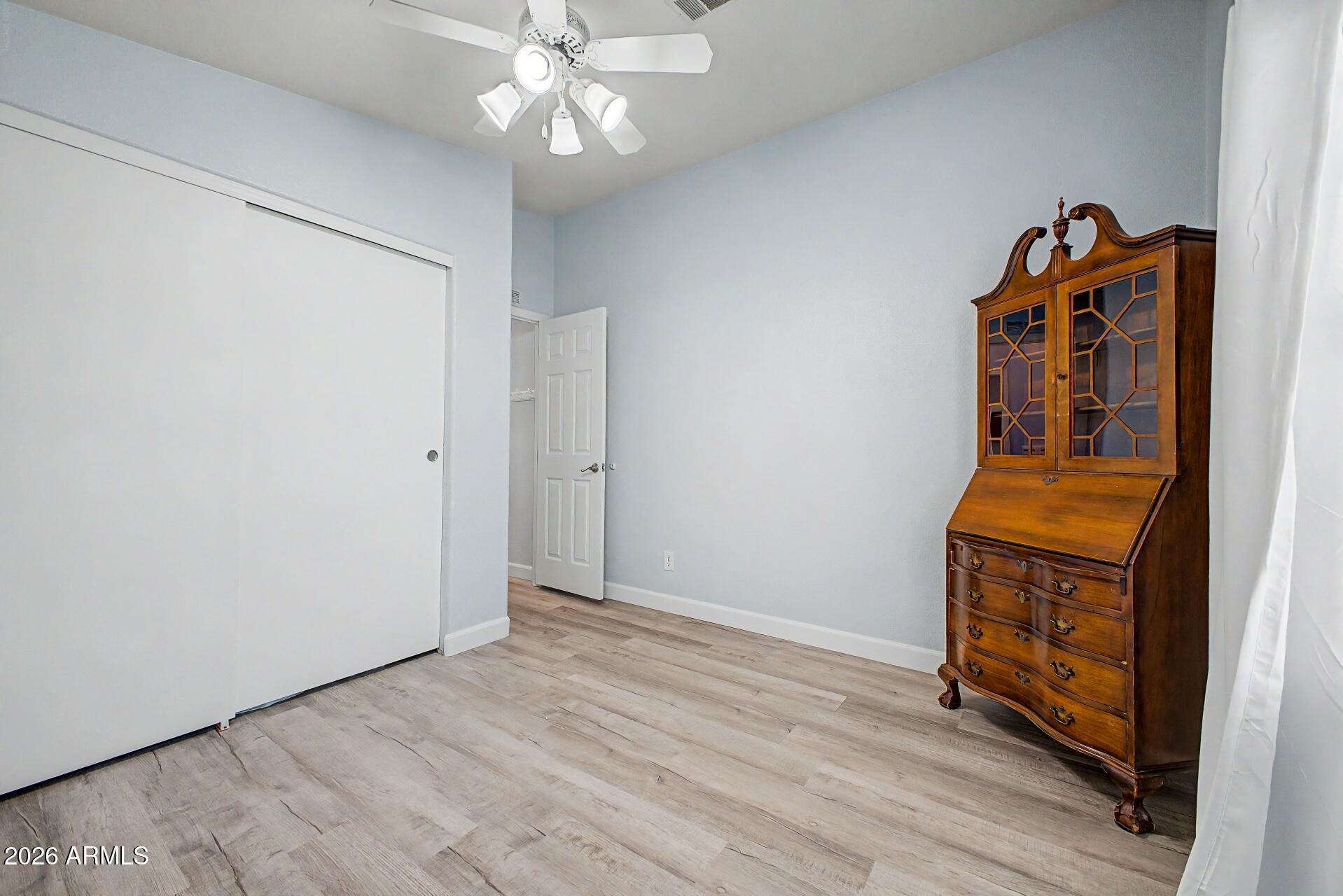 2550 South Ellsworth Road, Unit 50 Mesa, AZ 85209 - Photo 23 of 45 an empty room with wooden floor fan and windows