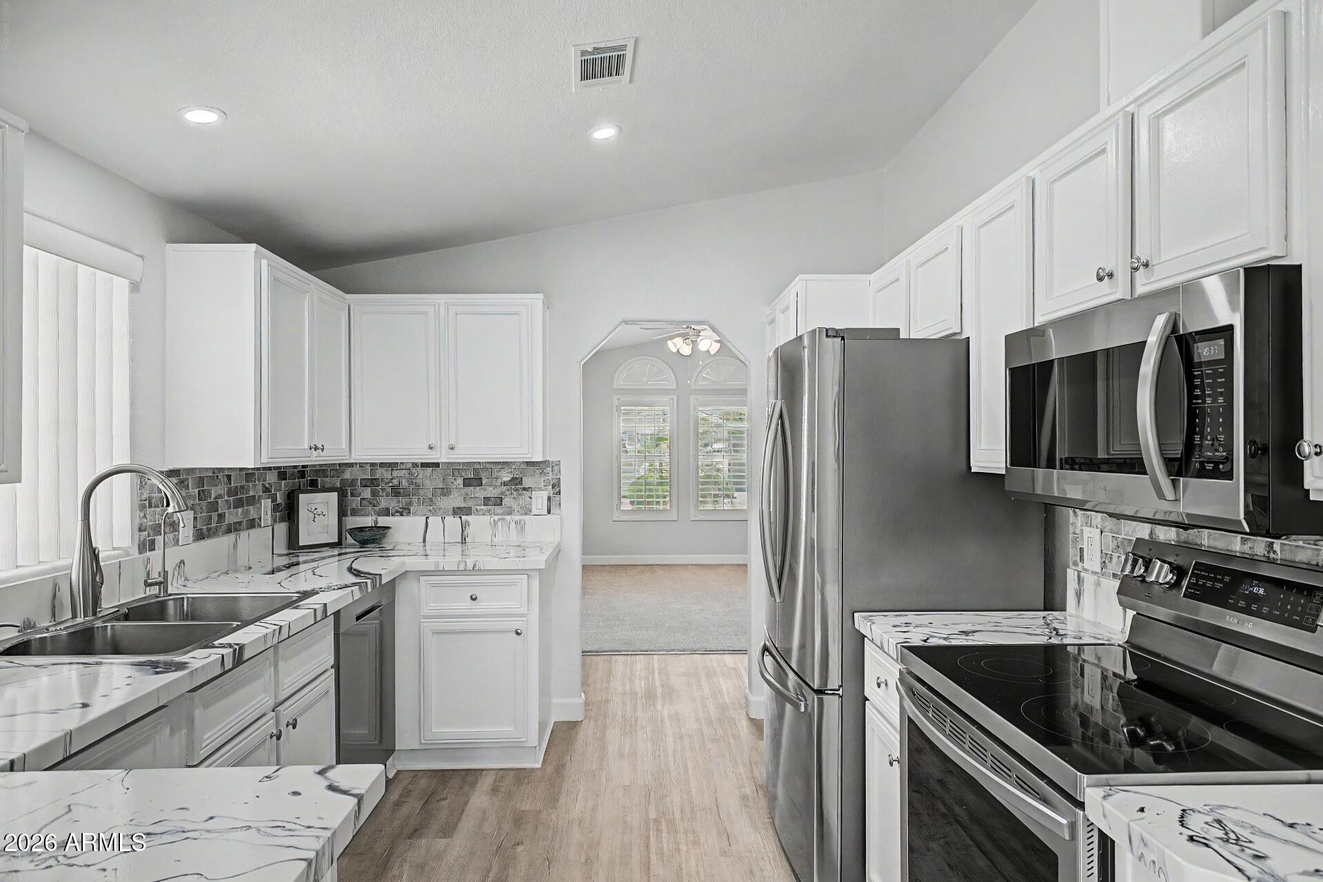 2550 South Ellsworth Road, Unit 50 Mesa, AZ 85209 - Photo 10 of 45 a kitchen with a sink stainless steel appliances and cabinets