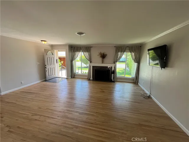 an empty room with wooden floor and a fireplace