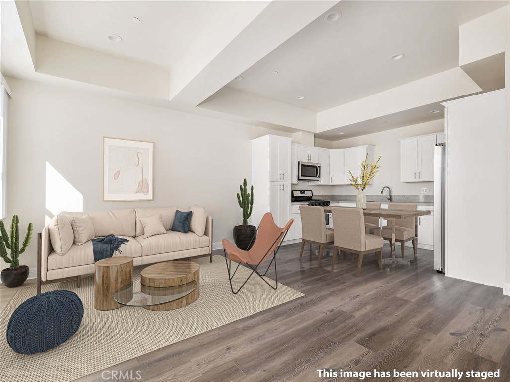 a living room with lots of furniture and view of kitchen