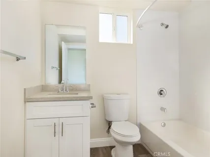 a bathroom with a granite countertop toilet a sink and a bathtub