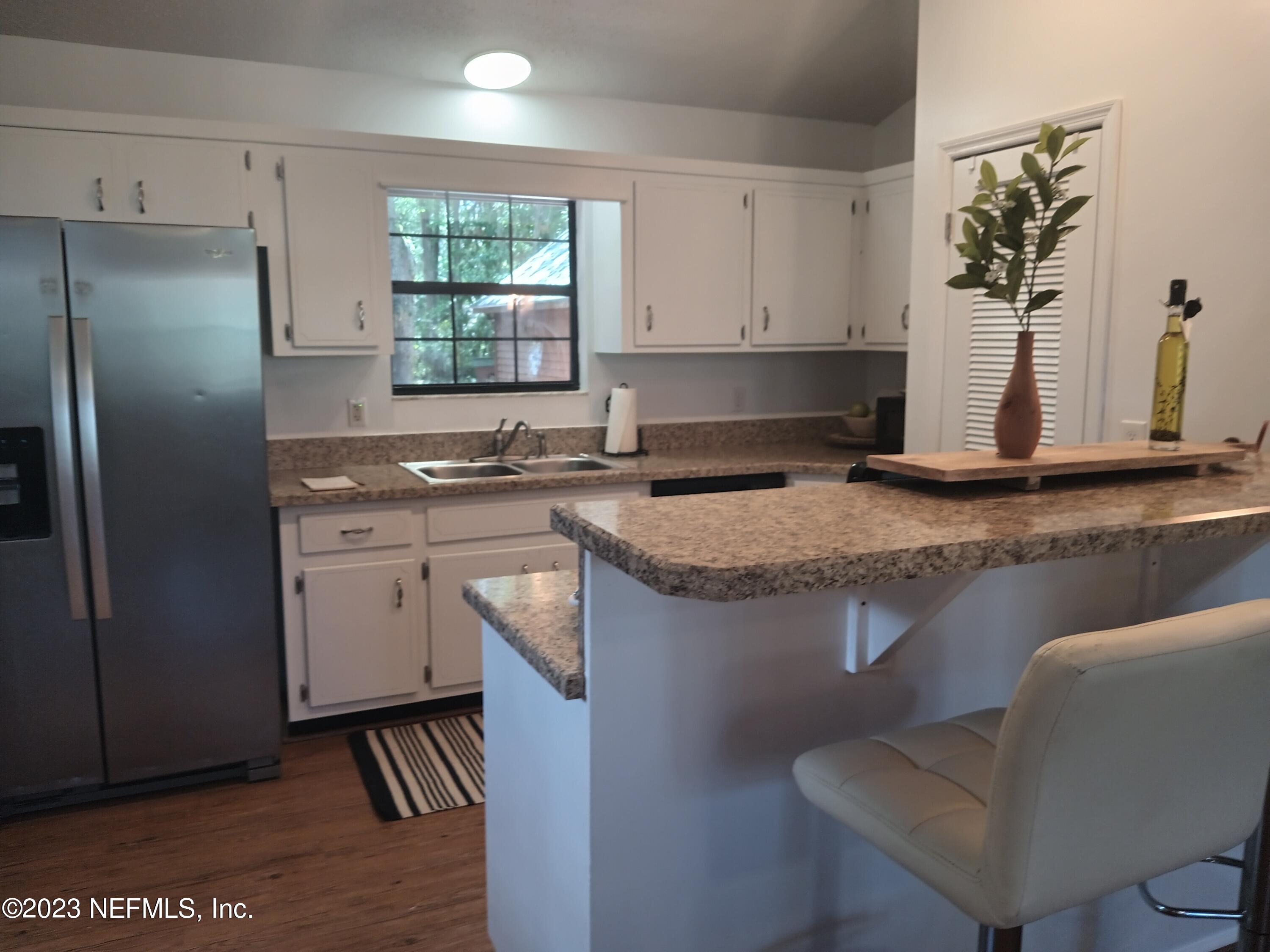 97612 Pirates Point Road Yulee, FL 32097 - Photo 11 of 23 a kitchen with stainless steel appliances granite countertop a sink stove and refrigerator