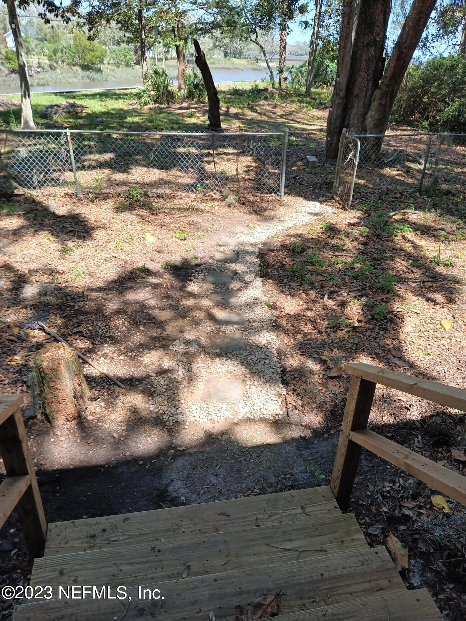 97612 Pirates Point Road Yulee, FL 32097 - Photo 19 of 23 a view of backyard with wooden floor and outdoor seating