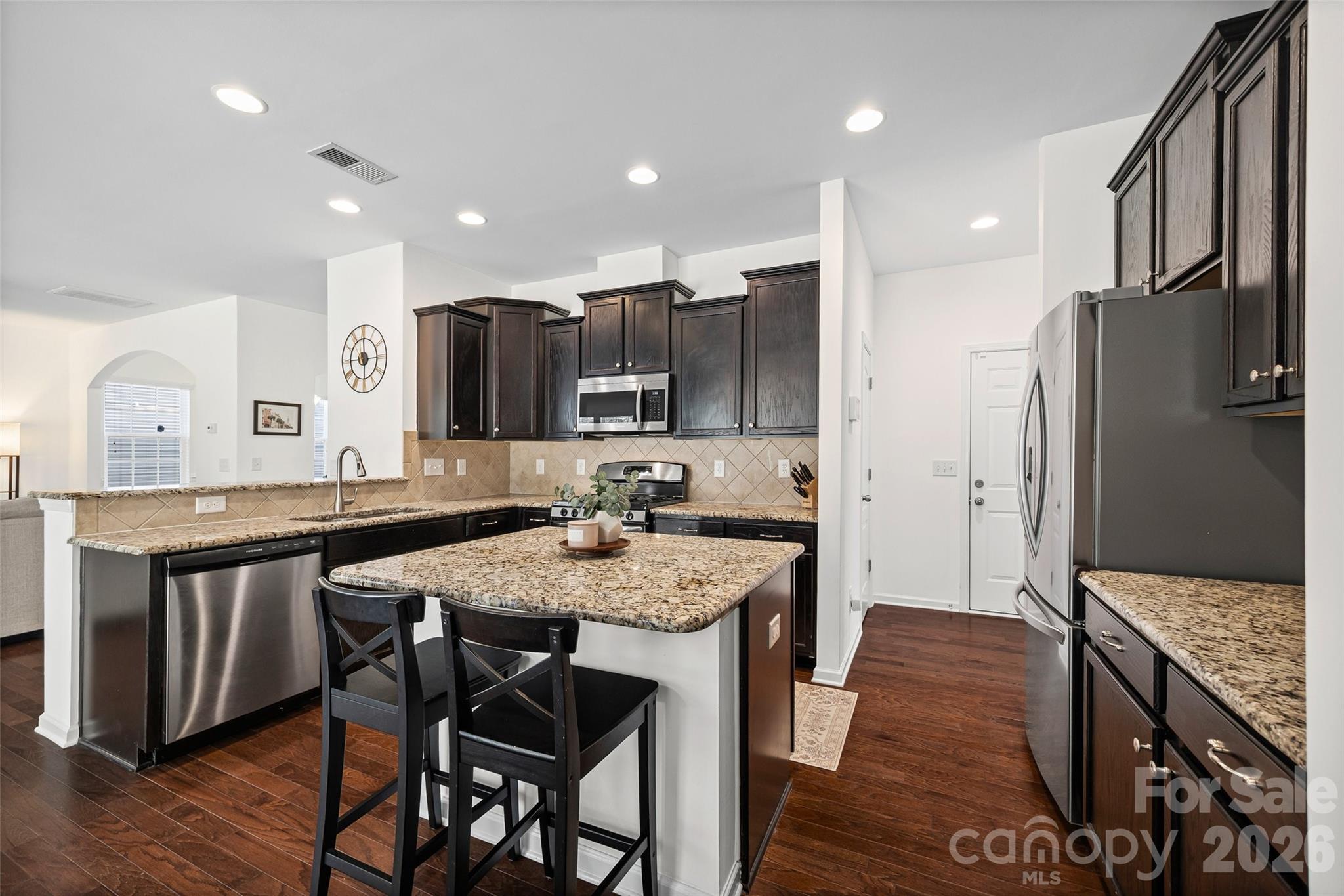 4470 Haddington Drive Indian Land, SC 29707 - Photo 11 of 27 a kitchen with stainless steel appliances granite countertop a kitchen island hardwood floor sink stove dining table and chairs