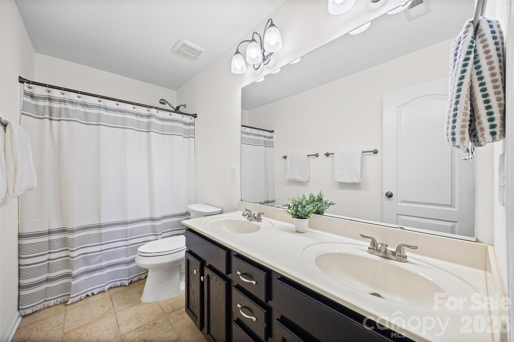 4470 Haddington Drive Indian Land, SC 29707 - Photo 21 of 27 a bathroom with a granite countertop sink a toilet and a large mirror