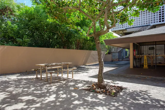 a view of a patio with table and chairs with wooden fence