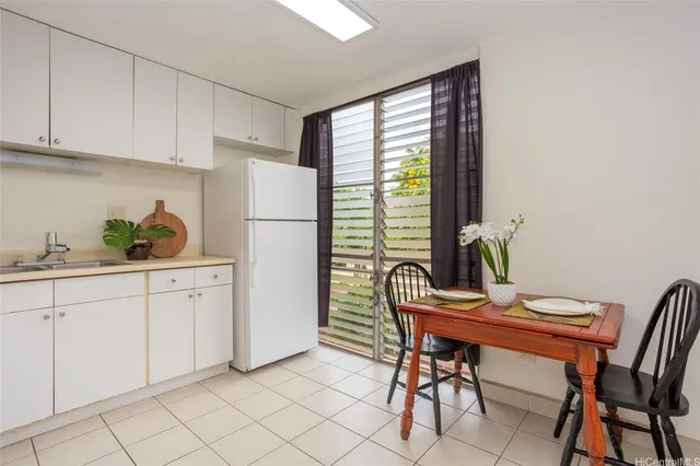 a kitchen with a white table and chairs in it