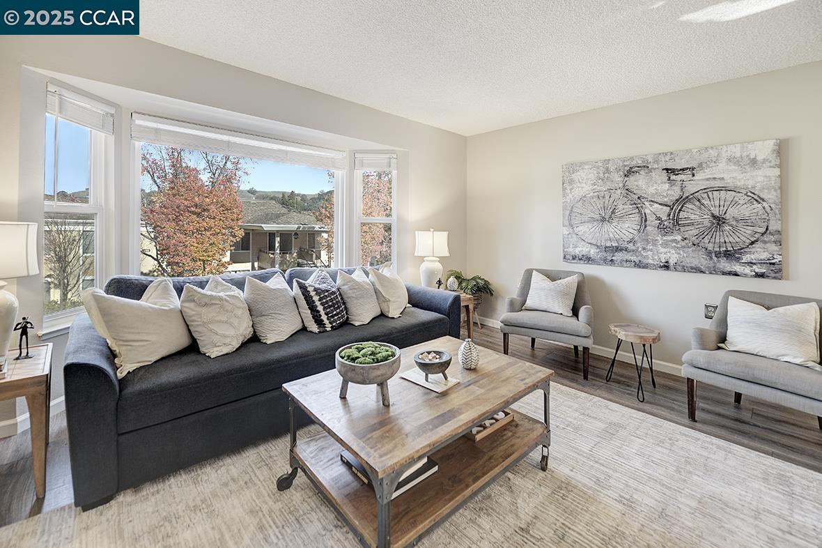 1405 Ptarmigan Drive, Unit 1 Walnut Creek, CA 94595 - Photo 12 of 39 a living room with furniture a large window and a table