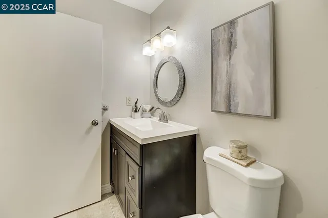 a bathroom with a granite countertop sink a toilet and a mirror