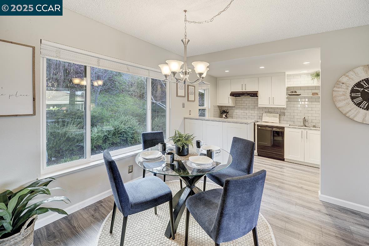1405 Ptarmigan Drive, Unit 1 Walnut Creek, CA 94595 - Photo 5 of 39 a dining room with furniture a chandelier and wooden floor