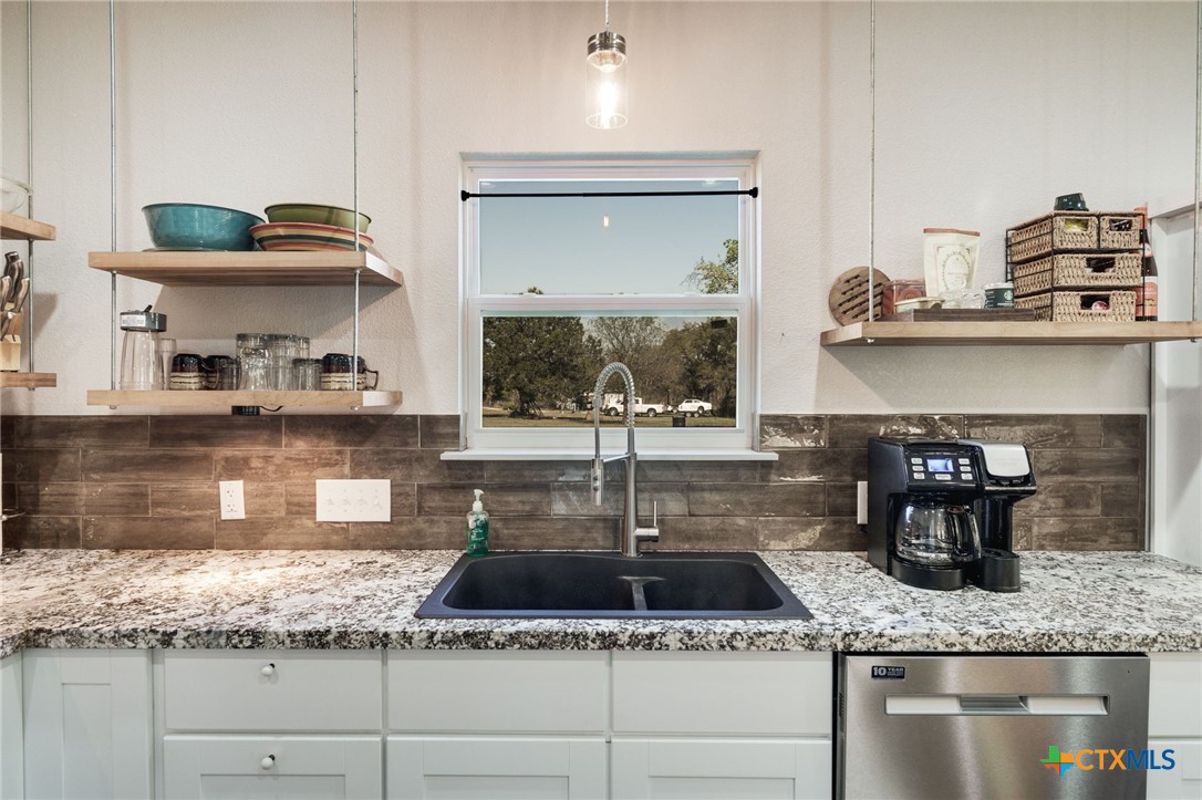 469 Whispering Oaks Loop Killeen, TX 76549 - Photo 13 of 48 a kitchen with granite countertop a sink a stove and cabinets