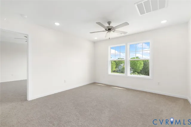 an empty room with a window and a ceiling fan
