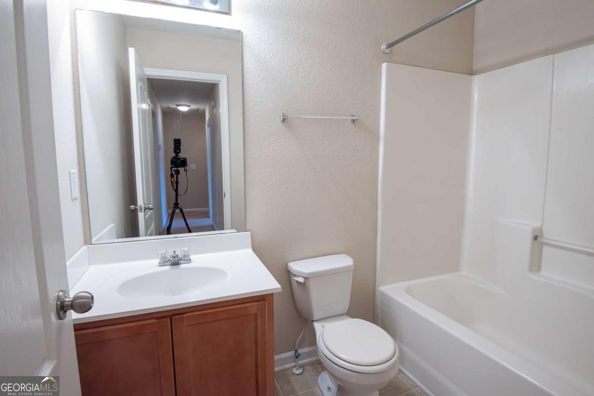 1259 Chinon Point Lithonia, GA 30058 - Photo 25 of 27 a bathroom with a sink a toilet and shower