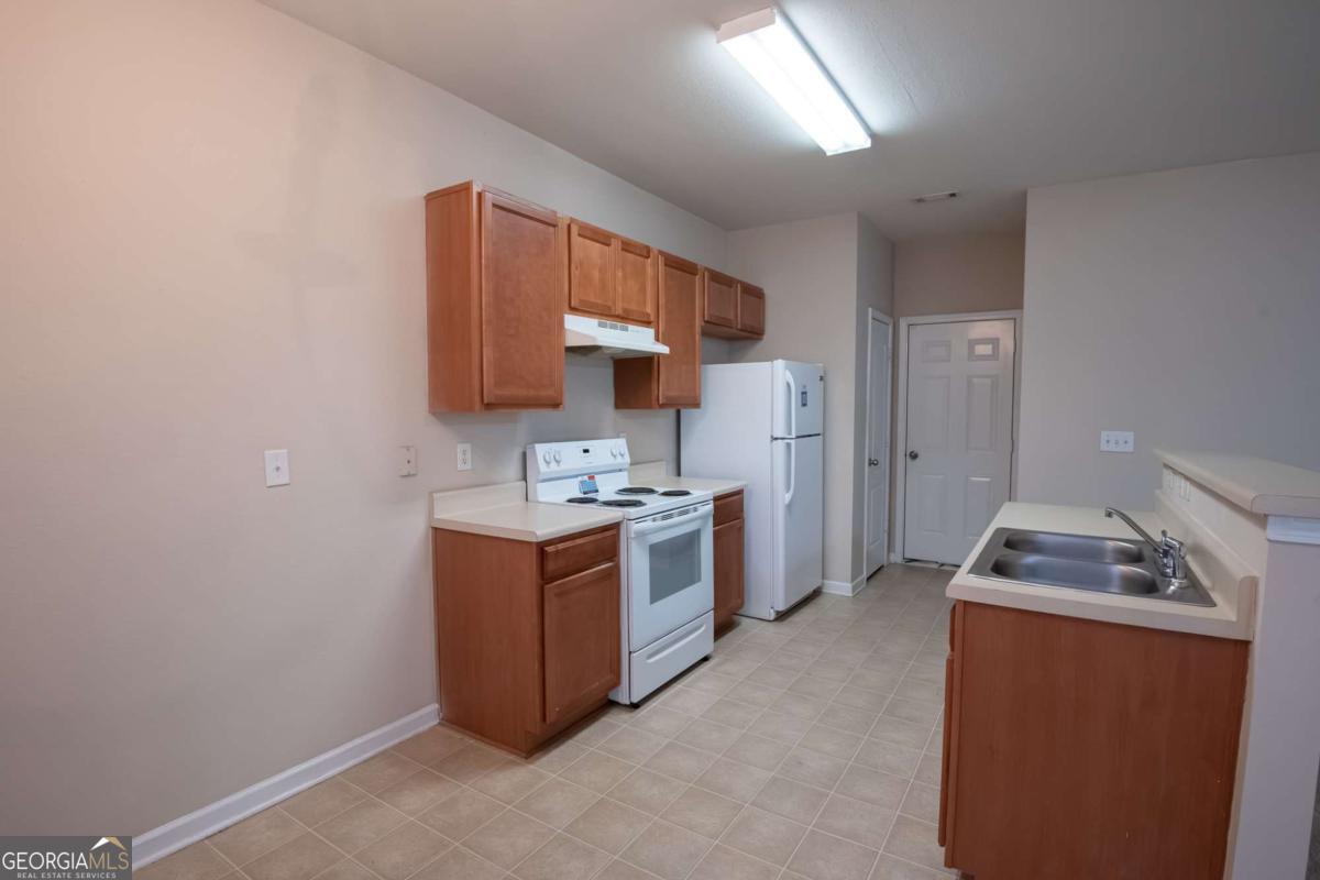 1259 Chinon Point Lithonia, GA 30058 - Photo 5 of 27 a kitchen with stainless steel appliances a stove a sink a refrigerator and cabinets