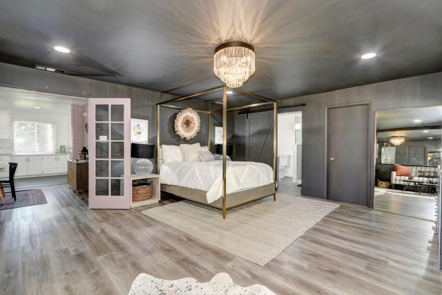 a bedroom with a large bed and a chandelier