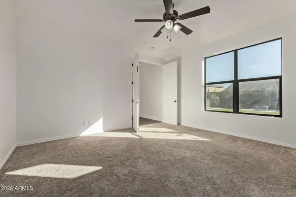 an empty room with windows and fan
