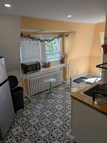 a view of a workspace with furniture and a window
