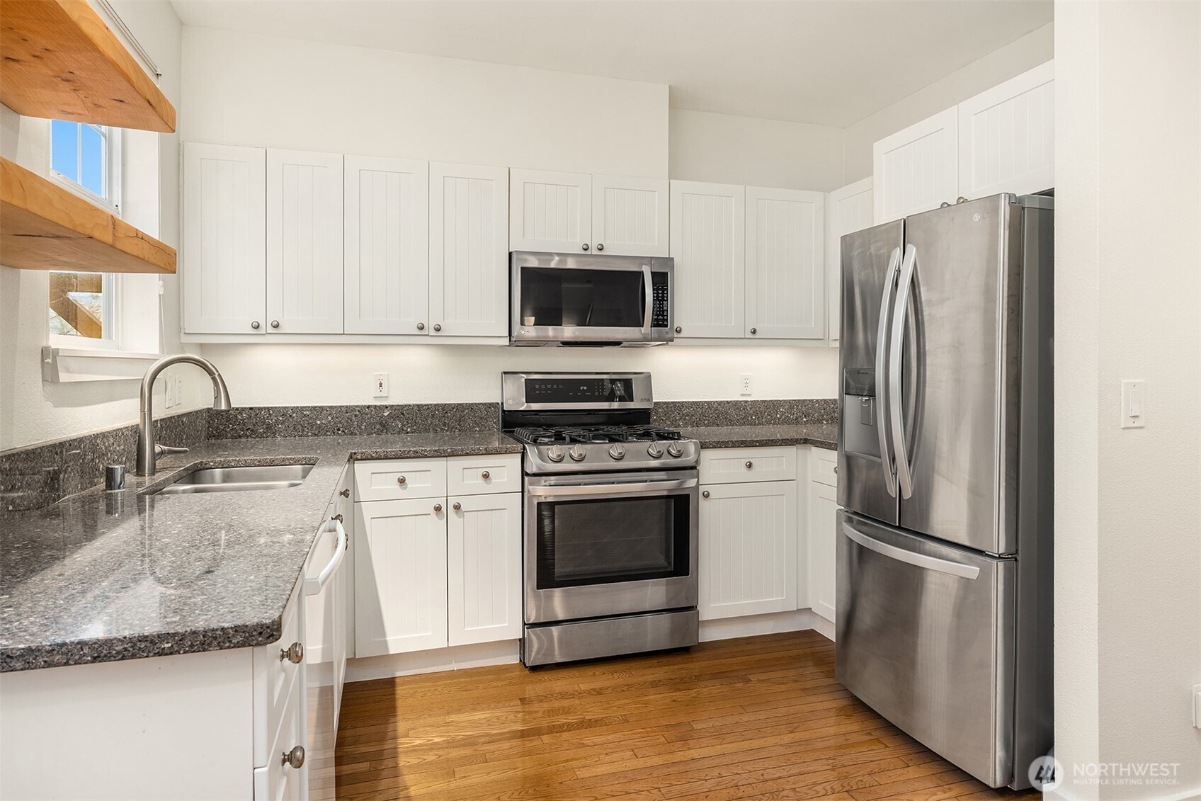 5430 California Avenue Southwest, Unit 2D Seattle, WA 98136 - Photo 11 of 26 a kitchen with granite countertop a refrigerator stove and microwave