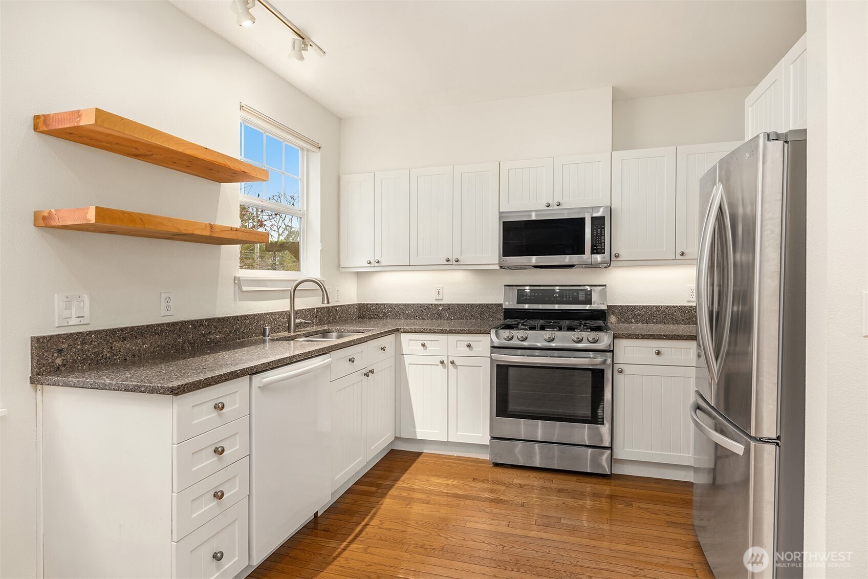 5430 California Avenue Southwest, Unit 2D Seattle, WA 98136 - Photo 12 of 26 a kitchen with granite countertop a stove a sink and a refrigerator