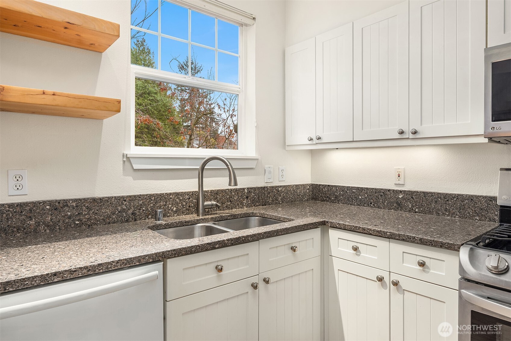 5430 California Avenue Southwest, Unit 2D Seattle, WA 98136 - Photo 13 of 26 a kitchen with granite countertop a sink window and cabinets
