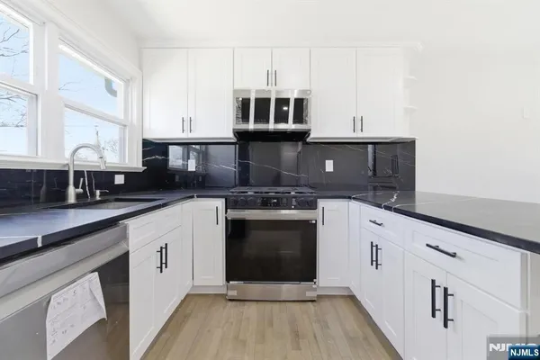 a kitchen with stainless steel appliances granite countertop a stove and a sink