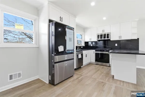 a kitchen with stainless steel appliances granite countertop a refrigerator and a stove top oven