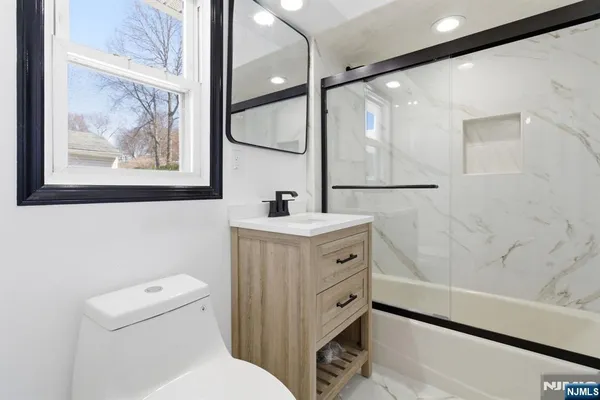 a bathroom with a sink mirror vanity and toilet