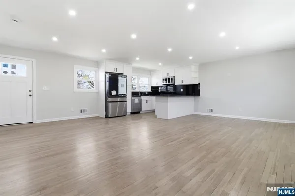 a view of kitchen with refrigerator and microwave