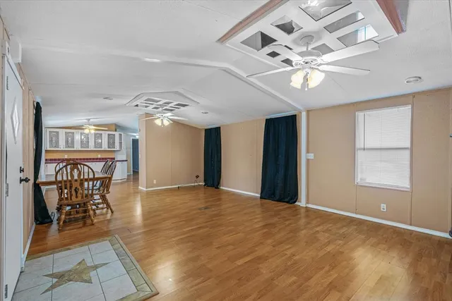 a view of a livingroom with furniture a chandelier and wooden floor