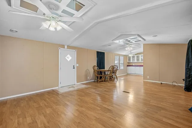 a view of a livingroom with wooden floor and a ceiling fan