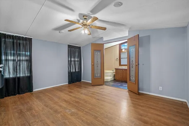 a view of a big room with wooden floor and natural light