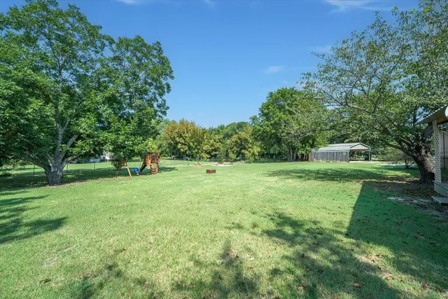 a green field with lots of trees in it