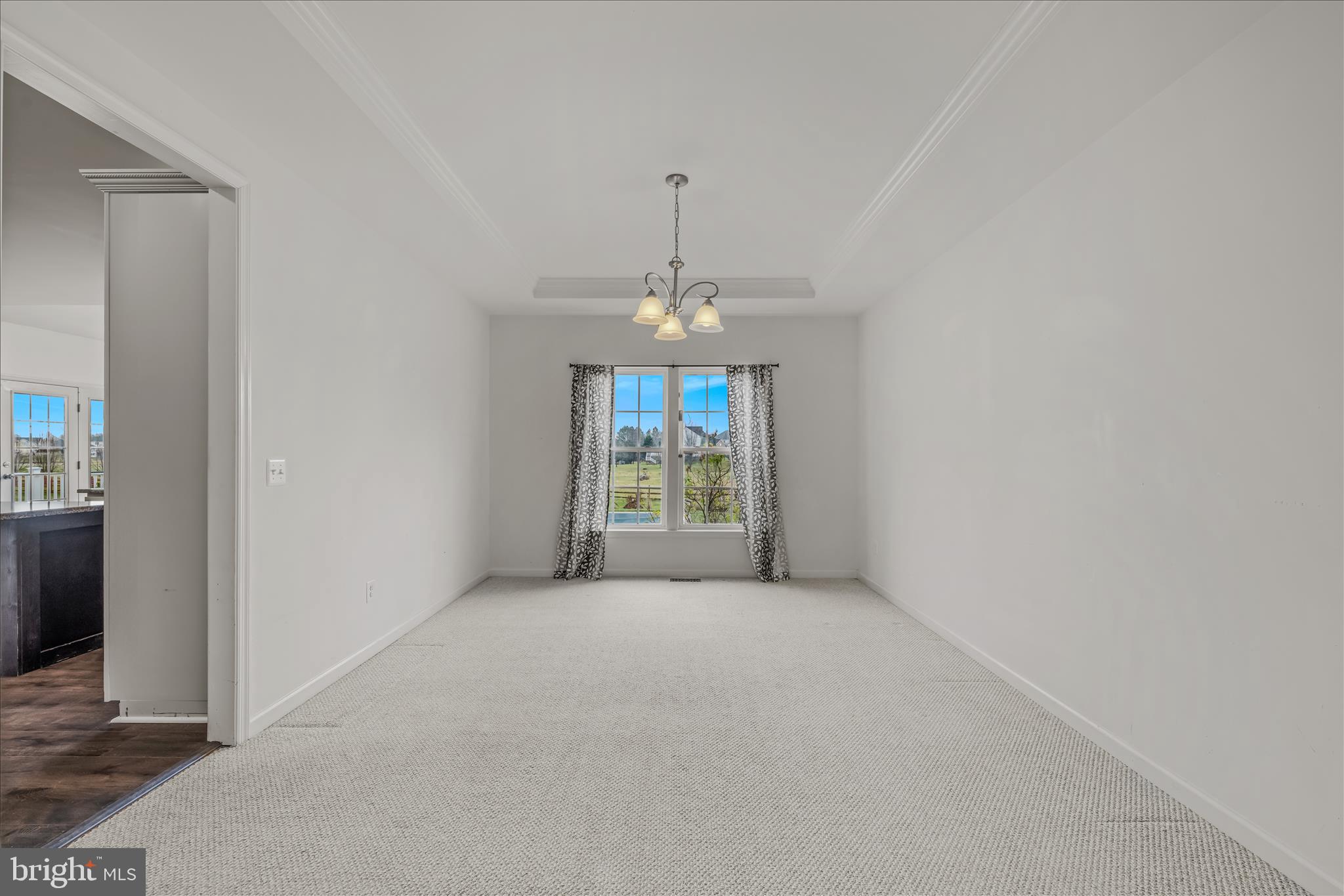 109 Turnberry Drive Charles Town, WV 25414 - Photo 10 of 77 an empty room with windows and chandelier
