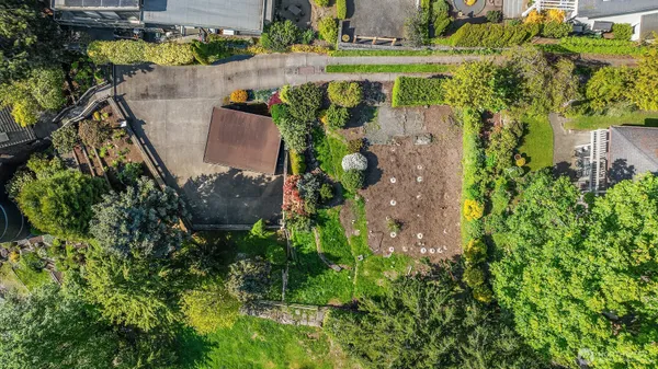 an aerial view of a house with a yard and large trees